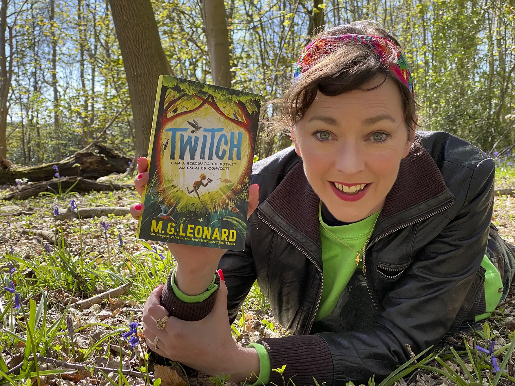 Author M. G. Leonard shows a copy of her book, Twitch, in a woodland setting